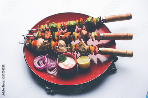Chicken Hariyali kakab or Malai malai kebab served with skewers and yogurt dip in a plate. selective focus