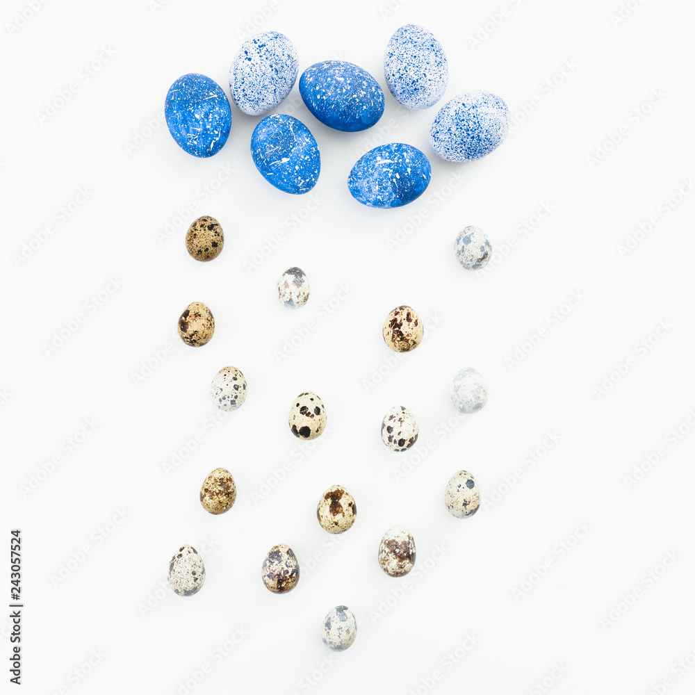 Blue Easter eggs with quail eggs on white background. Flat lay. Top view. Cloud and rain made of easter eggs, creative concept Blue Easter eggs with quail eggs on white background. Flat lay. Top view. Cloud and rain made of easter eggs, creative concept