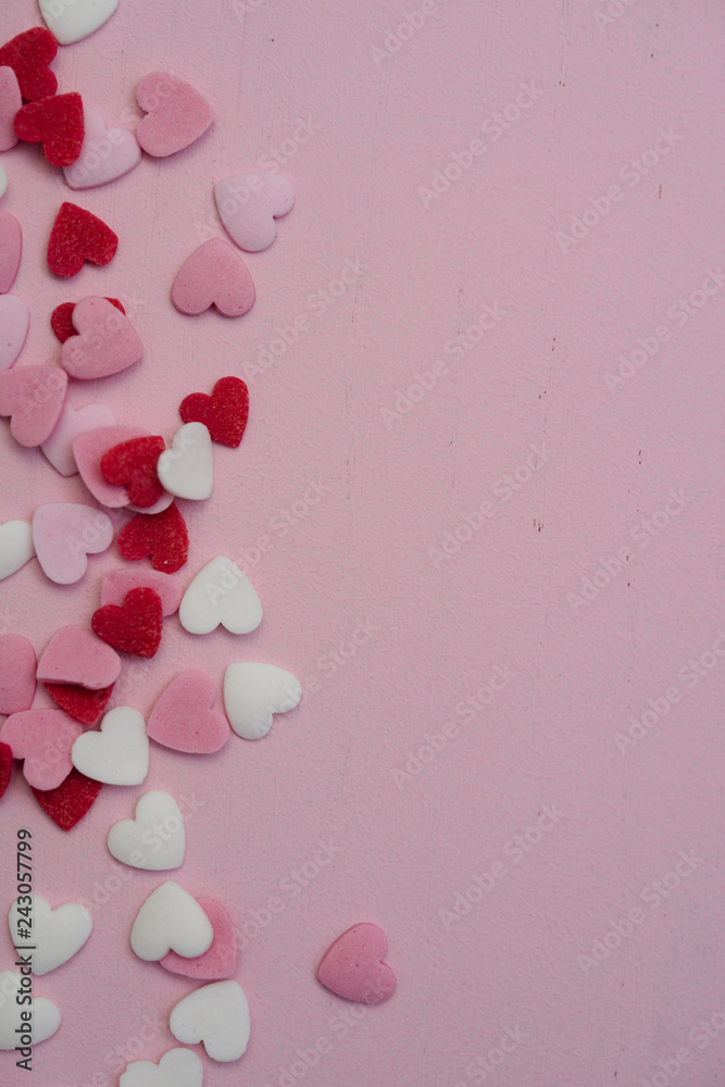 Flat lay with hundreds of tiny heart-shaped sugar sprinkles with space for copy text or love letter message as gift of symbol for affection and romantic feelings for Valentine's Day on February 14th
