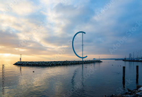 Dramatic tranquil silhouette beautiful sunset at Geneva lake with scenery of embankment Eole Sculptural landmark and background of pier in Lausanne, Switzerland.