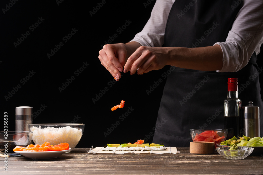The chef prepares Japanese sushi, horizontal photo. A concept of restaurants, books of recipes, menus, delicious food The chef prepares Japanese sushi, horizontal photo. A concept of restaurants, books of recipes, menus, delicious food