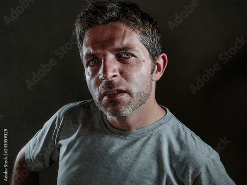 isolated dark background portrait of young upset and defiant man in arrogant and cocky pose looking with contempt and inquisitive stare in disgust emotion face expression