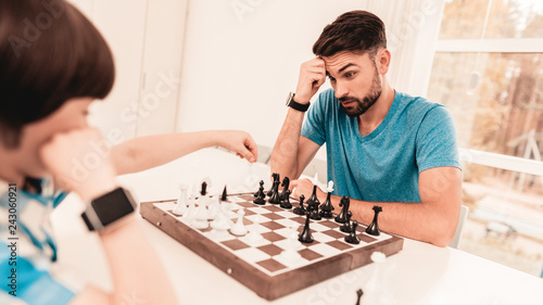 Bearded Father and Son Playing Chess on Table.