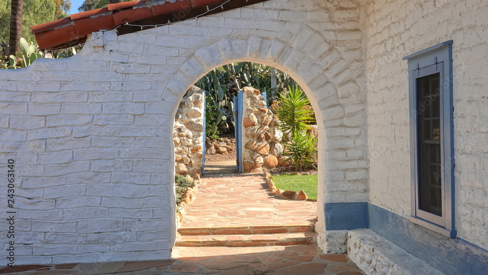 A stone archway leads to a garden