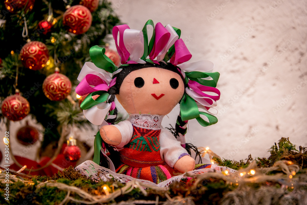 Fotografia do Stock: muñeca mexicana navideña, con arbol de navidad y  esferas rojas, traje tipico, marias, ojos grandes, tierna, fondo blanco,  listones de colores, luces navideñas | Adobe Stock