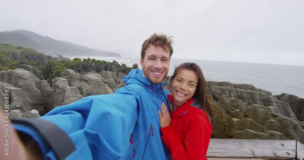 Travel tourist couple taking selfie video by Punakaiki Pancake Rocks in Paparoa National Park New Zealand. SLOW MOTION. Travel tourist couple taking selfie video by Punakaiki Pancake Rocks in Paparoa National Park New Zealand. SLOW MOTION.