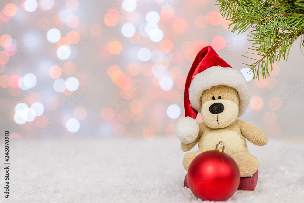 Toy bear with red christmas hat and tree toy ball. Holidays background with copy space for your text