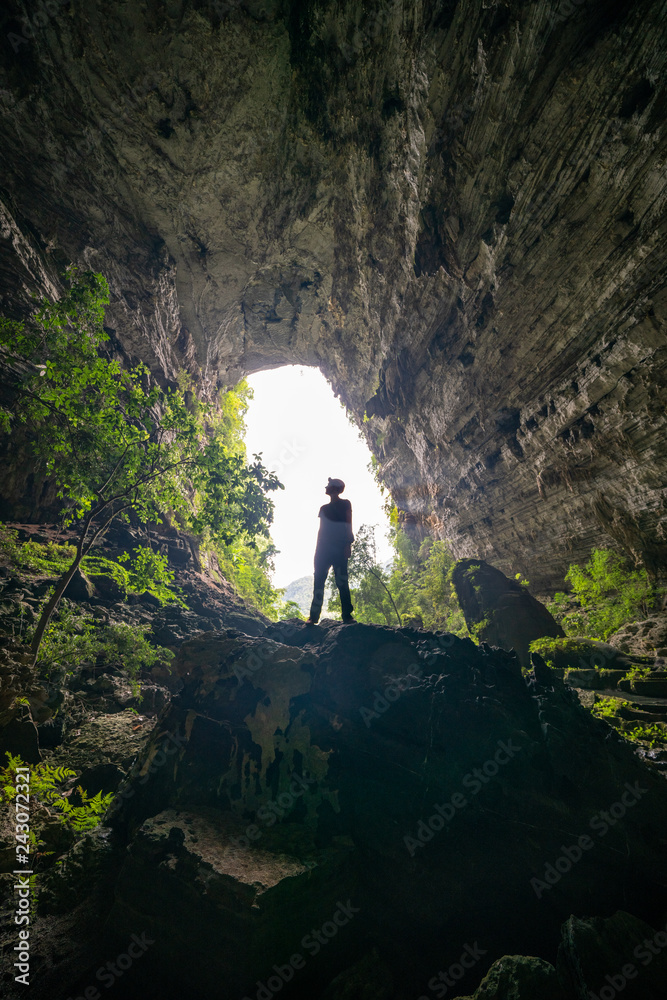 Silhouette of Man Caving with Headlamp / Spelunking in Vietnam Tour