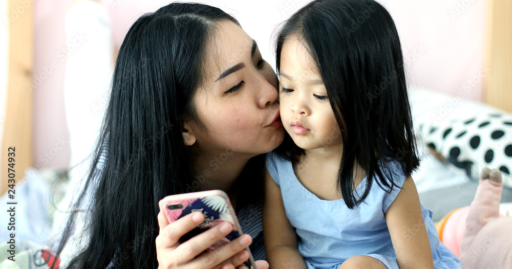 Mother and daughter enjoy playing smartphone Mother and daughter enjoy playing smartphone