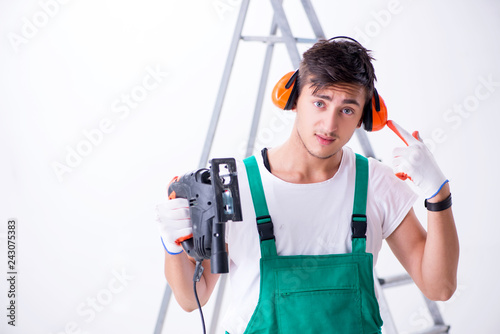 Young worker with earmuffs in noise cancelling concept 