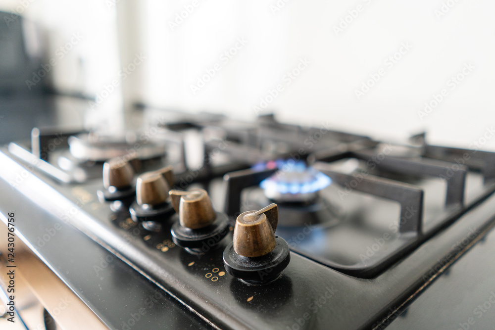 Closeup shot of blue fire from domestic kitchen hob. Gas cooker with burning flames propane gas.