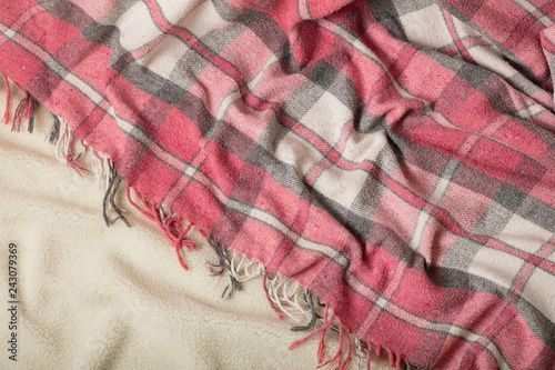 Winter time. A cozy warm pink blanket and a cup of coffee and croissants on the bed.