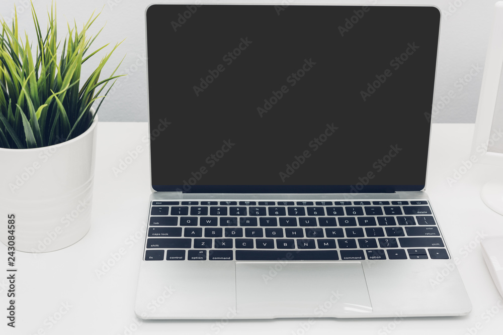 Laptop computer blank screen on white desk Laptop computer blank screen on white desk