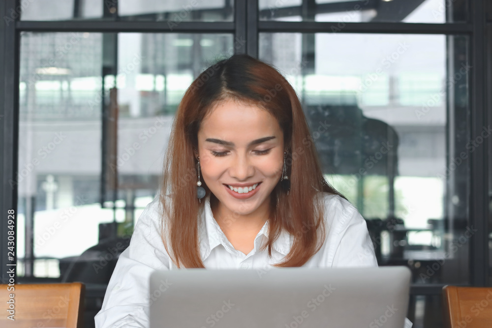 Smiling young Asian business woman with laptop working in modern office. Smiling young Asian business woman with laptop working in modern office.