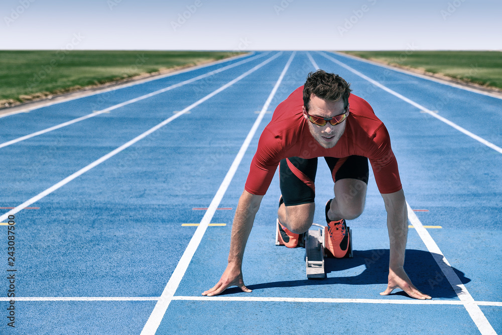 Foto Stock Sprinter athlete ready to start running race waiting at line on  starting blocks on blue run tracks at outdoor stadium. Focus and motivation  sport and fitness concept. | Adobe Stock