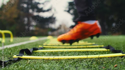 Soccer agility training equipment. Professional football player with agility ladder. 4k slow motion