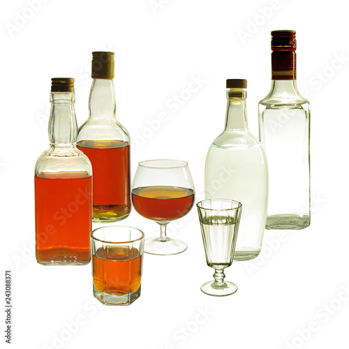 Glasses and bottles of gin and whiskey. Isolated on white