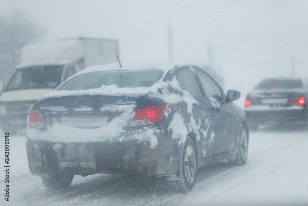 dangerous winter road conditions on a highway with oncoming traffic during heavy snowfall