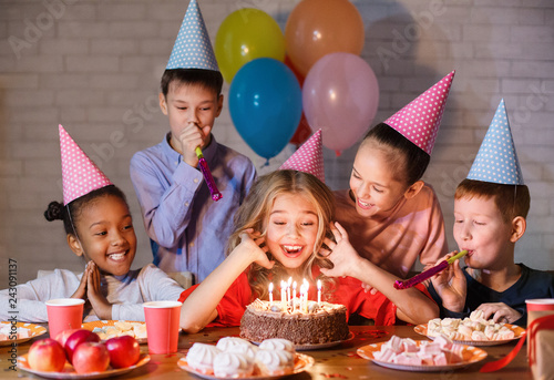 Kids looking at birthday cake with candles
