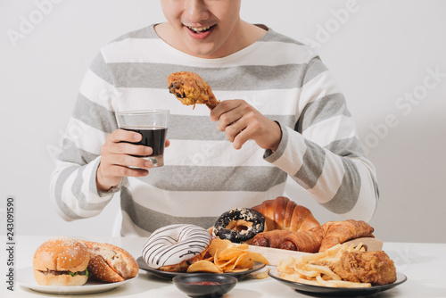 People eating fast food concept hand holding deep fried chicken carbonated soft drink photo