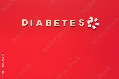 Diabetes inscription, spoon with sugar on red background