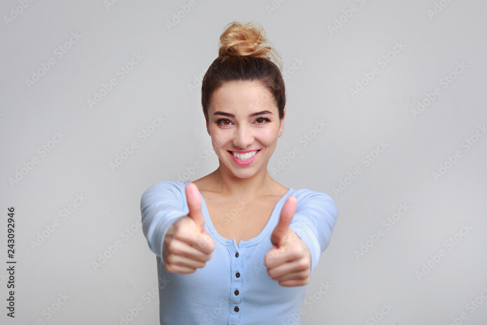 Happy woman showing thumbs up and smiling at camera Happy woman showing thumbs up and smiling at camera