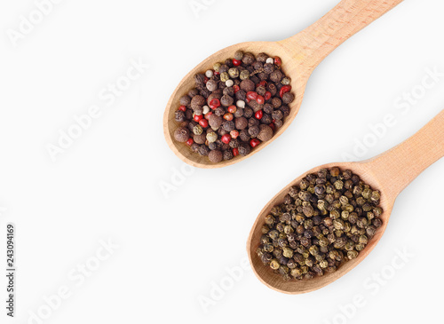 Wooden spoons with aromatic culinary condiments on white