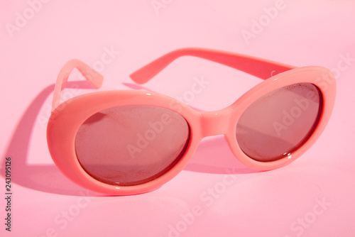 coral sunglasses on pink background