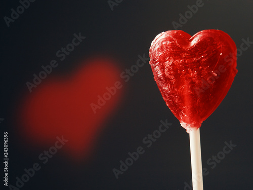 Fotografija Candy red heart rotating on black