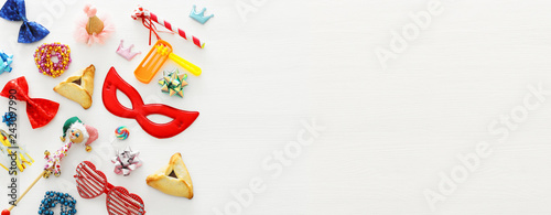 Purim celebration concept (jewish carnival holiday) over wooden white background. Banner.