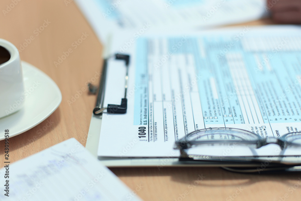Obraz premium U.S. Individual income tax return, tax 1040 at table.