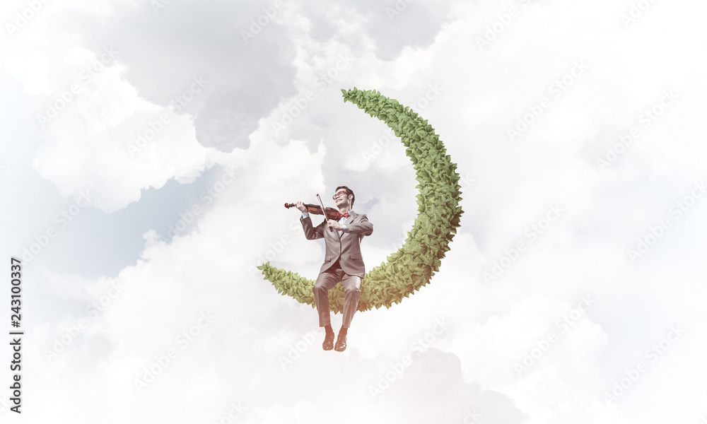 Fototapeta premium Handsome violinist on moon in blue sky play his melody