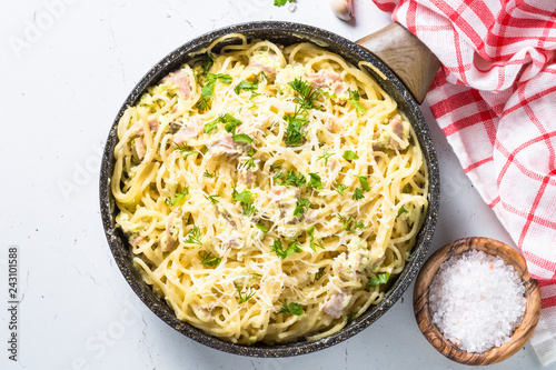 Pasta carbonara with bacon and cream sauce on white. 