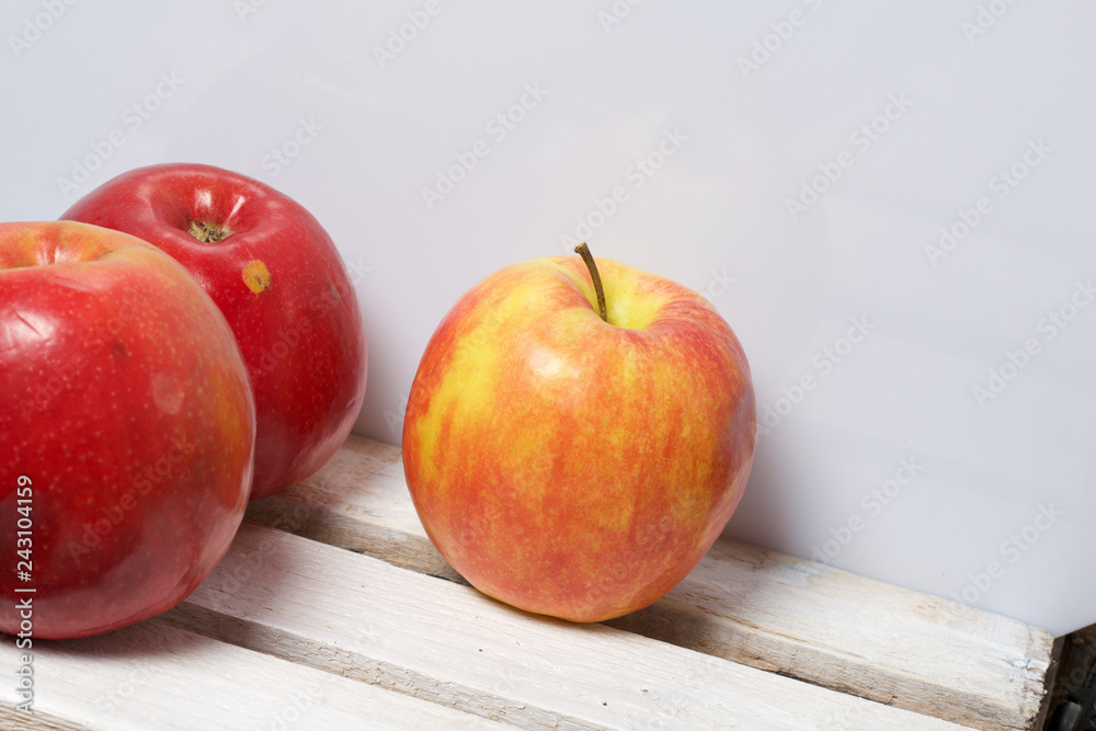 Ripe juicy apples. They lie on a wooden box. On a white background. Ripe juicy apples. They lie on a wooden box. On a white background.