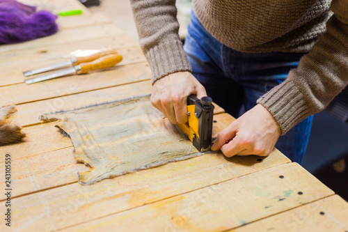 Professional male skinner, furrier working with mink fur skin at atelier, workshop. Fashion and leatherwork concept