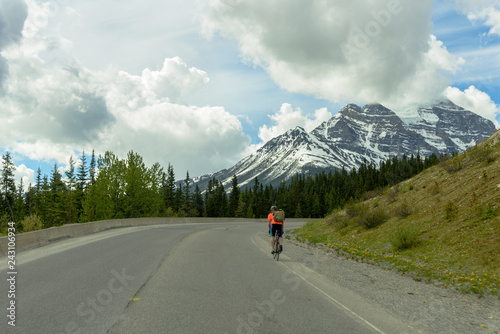 Cyclist riding bicycle through Trans Canada Highway, Alberta, Banff, Canada  © Yaya Ernst