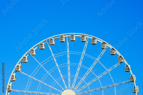 Big beautiful ferris wheel in the park against the blue sky.