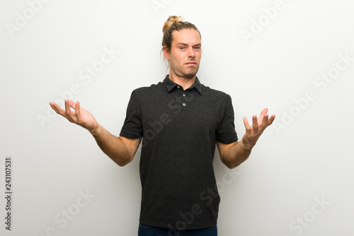 Blond man with long hair over white wall unhappy and frustrated with something because not understand something