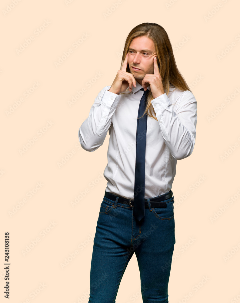 Blond businessman with long hair having doubts and thinking on isolated background Blond businessman with long hair having doubts and thinking on isolated background