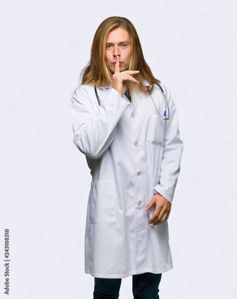 Doctor man showing a sign of silence gesture putting finger in mouth on isolated background Doctor man showing a sign of silence gesture putting finger in mouth on isolated background