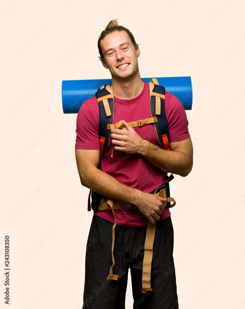 Hiker man with mountain backpacker happy and smiling on isolated background