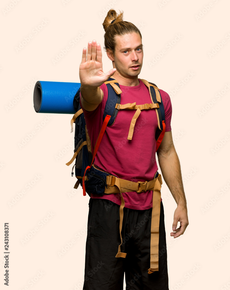 Hiker man with mountain backpacker making stop gesture denying a situation that thinks wrong on isolated background Hiker man with mountain backpacker making stop gesture denying a situation that thinks wrong on isolated background