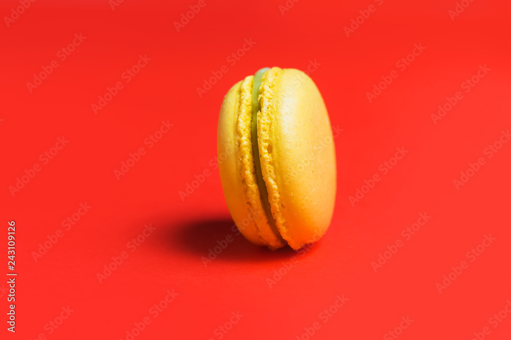 Closeup of yellow sweet macaroon on red background Closeup of yellow sweet macaroon on red background