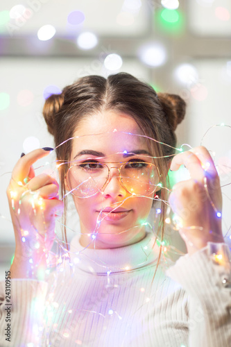 Young woman with glasses and christmas lights