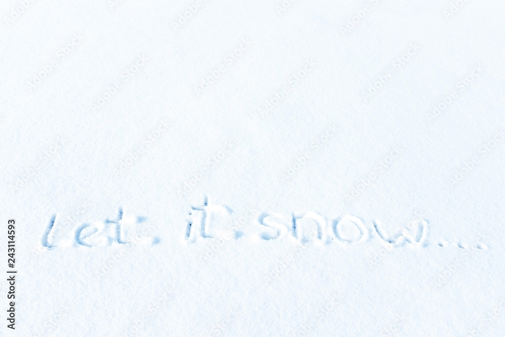 Closeup text LET IT SNOW written on snow