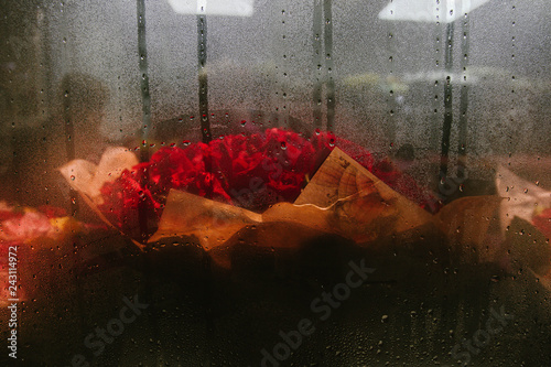 a bouquet of flowers in the store behind the misted glass