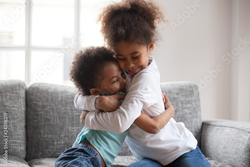 Tableau sur toile Cute happy african american siblings hugging cuddling feeling love and connectio