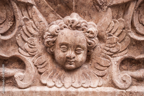 Depiction of cherub, winged unearthly christian biblical creature. Stone carved memorial plaque on the wall of Mariazellerkapelle on St. Peter's cemetery, Salzburg, Austria
