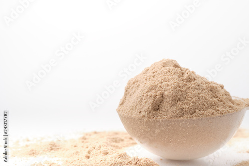 Brown chocolate protein powder and scoops on white background. - Image