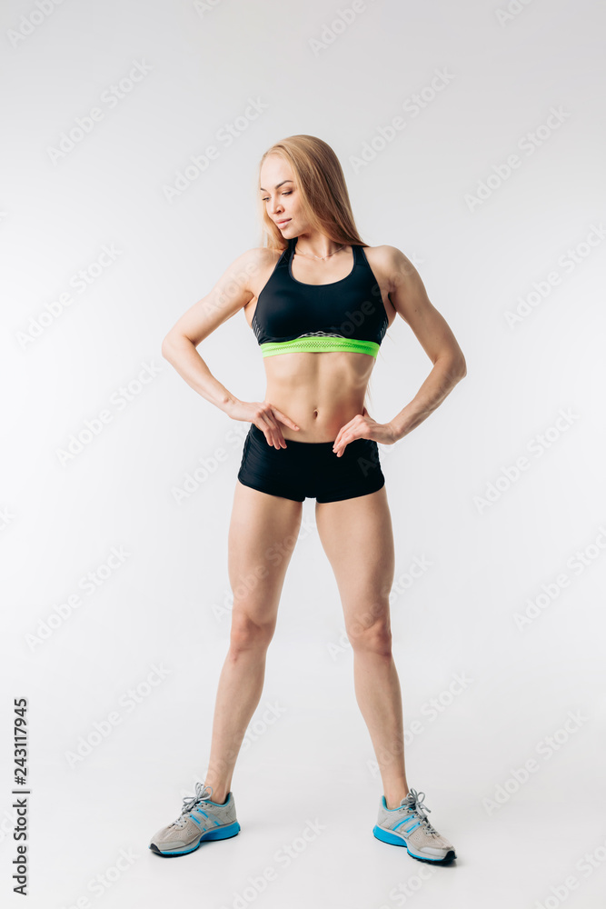 pleasant fitness woman with ideal waste is looking down. studio shot. results of intensive workout.body and health care pleasant fitness woman with ideal waste is looking down. studio shot. results of intensive workout.body and health care